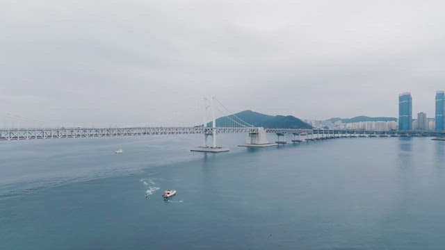 고요한 바다 위의 긴 다리와 보트
