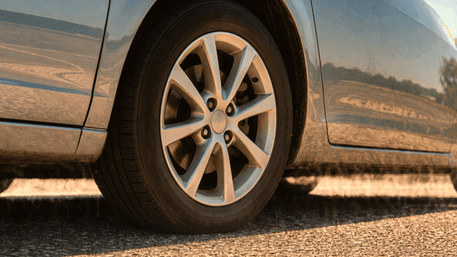 Car tires on sunlit road