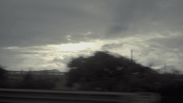 달리는 차안에서 보이는 넓은 들판 위 흐린 하늘