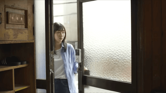 문을 통해 집에 들어오는 여성