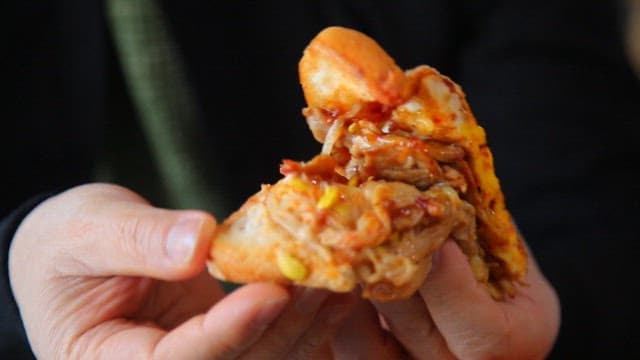 Holding toast with egg, pork bulgogi, and bean sprouts