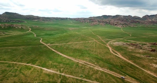 Vast green plains with distant mountains