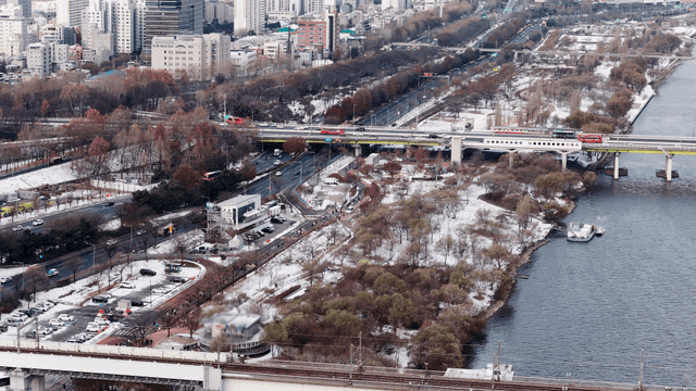 Snow-covered cityscape with river and roads