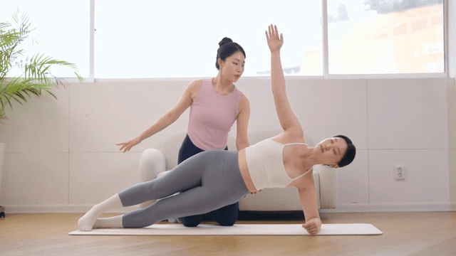 Yoga instructor guiding a student indoors