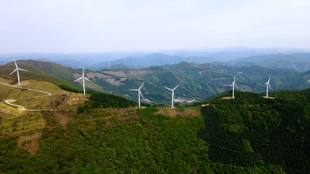 Wind turbines on a lush green mountain range