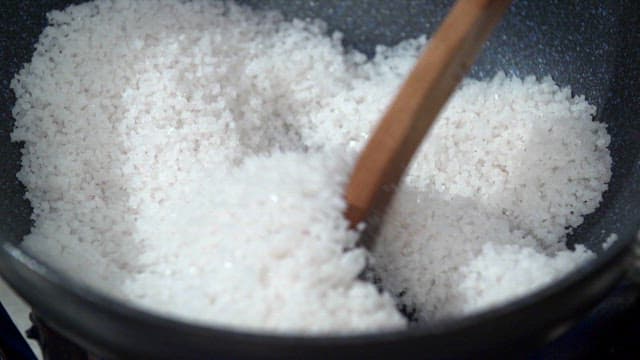 팬에서 소금을 저으며 요리하는 장면