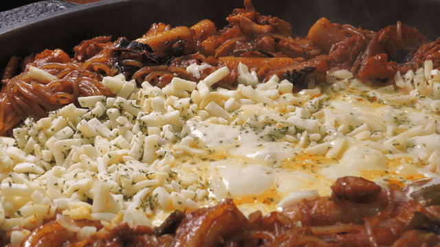 Spicy stir-fried chicken covered with cheese