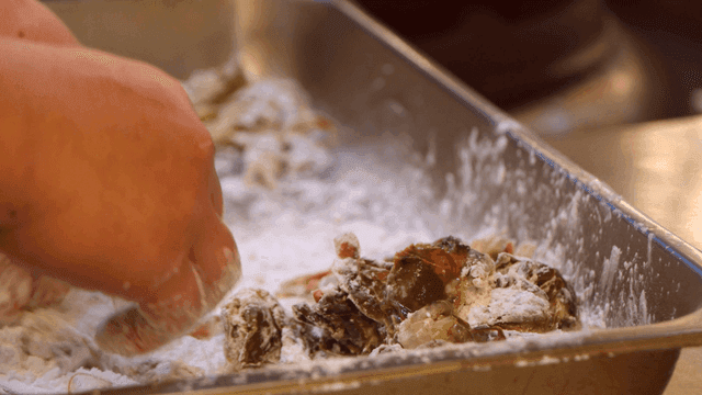 Chef coating crab in flour