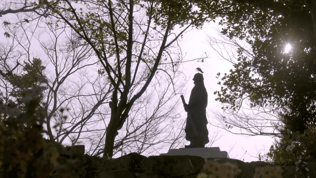 Statue in a serene forest with sunlight