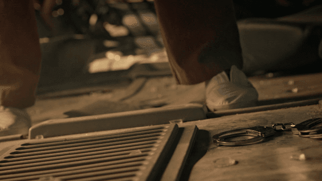 먼지 낀 바닥으로 수갑을 떨어트리고 돌아서는 사람