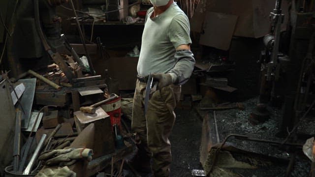 Worker handling metal in a workshop