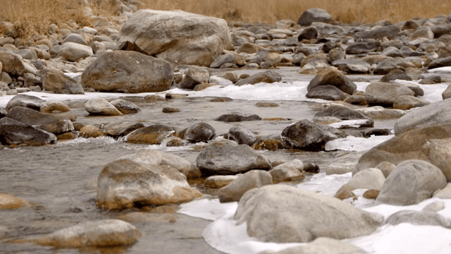 얼음이 낀 바위 사이로 흐르는 작은 시냇물