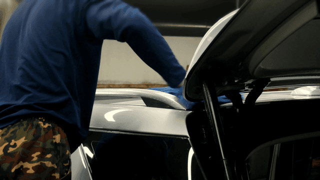 천으로 차를 닦는 작업자