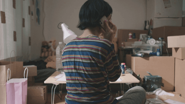 어수선한 방에서 전화하는 사람