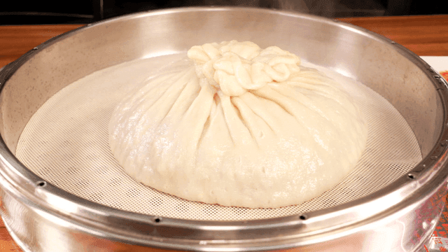 Large dumplings in steamer with opening lid