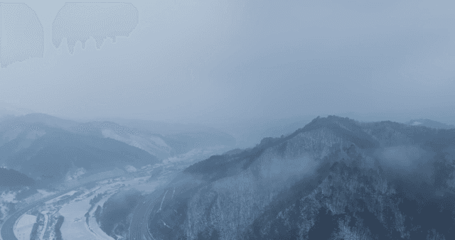Snow-covered mountains with mist