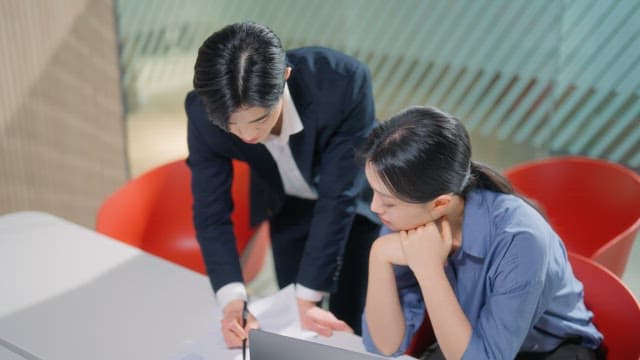 Two colleagues discussing work at a table