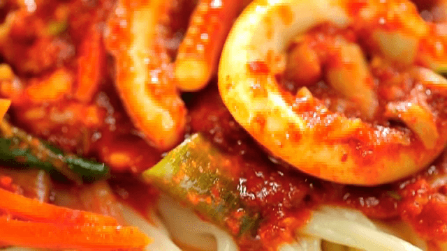 Noodle dish topped with spicy tir-fried squid