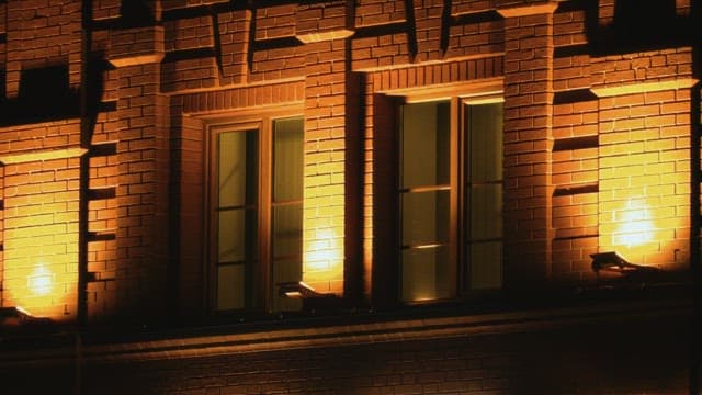 밤의 조명이 켜진 벽돌 건물의 창가
