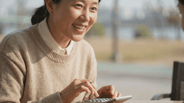 Woman smiling while using a calculator