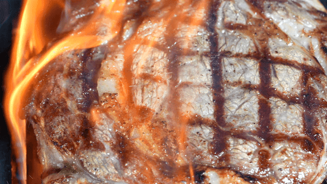 Grilled steak sizzling on a barbecue
