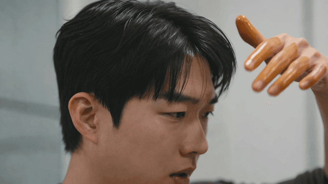 Young man applying hair product with his fingers
