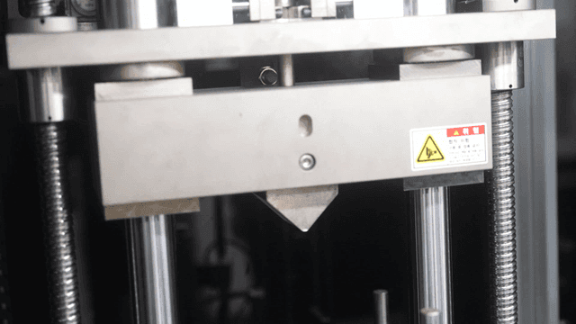 Close-up of a metal press machine in operation