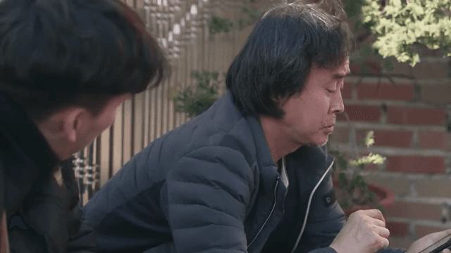 두 남자가 야외에서 대화하는 모습