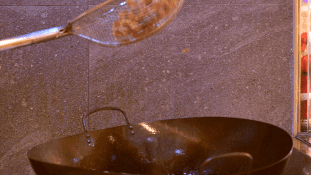 Draining oil from fried food in kitchen