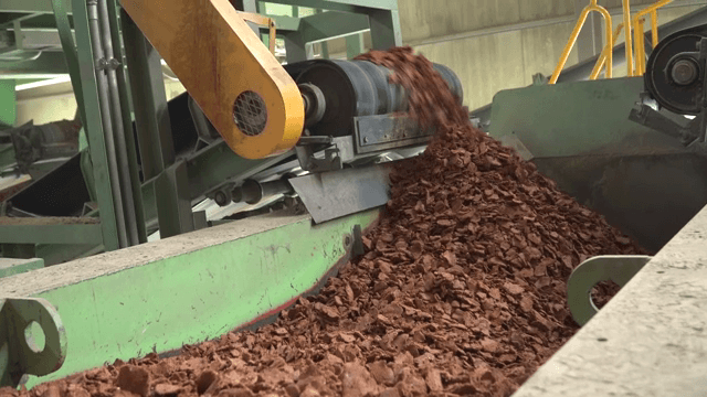 Brown material being processed in a machine