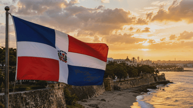 Dominican Republic flag fluttering on seashore at sunset