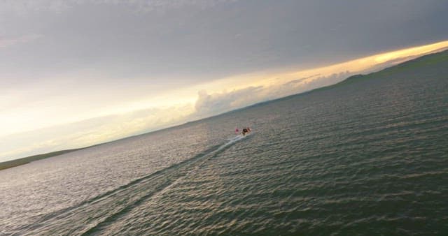 Boat speeding across a vast lake