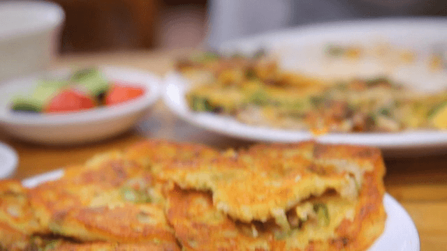 Mung bean pancake being picked up with chopsticks