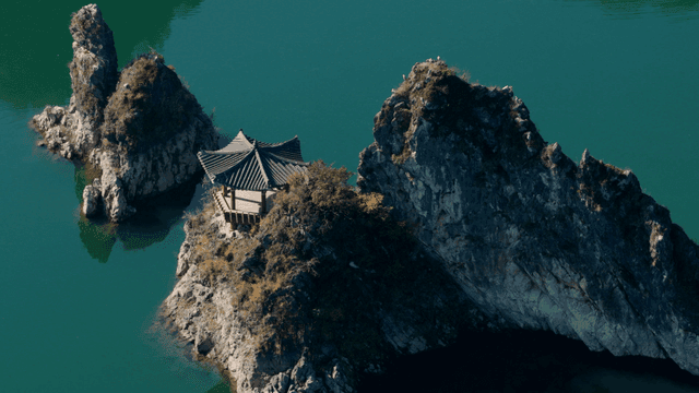 바위 섬 위의 전통 정자가 있는 호수