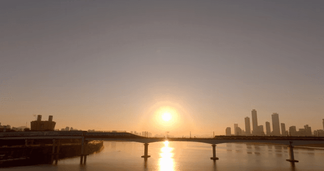 도시 스카이라인과 다리 위의 일출