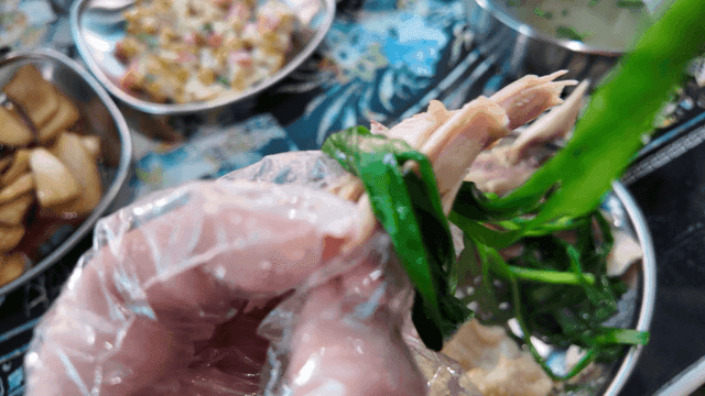 Hands eating chicken wrapped in chives
