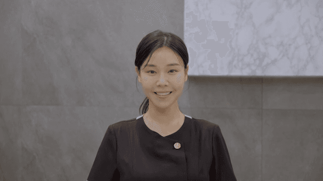 프론트 데스크 속 미소 짓는 여성