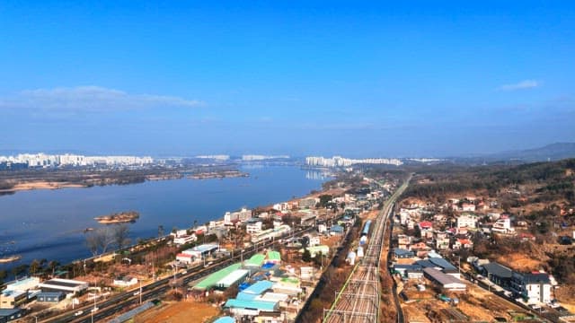 맑은 하늘 아래 분주한 강변 도시 경관