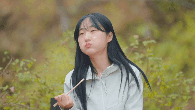 Young woman eating gimbap on autumn mountain trail