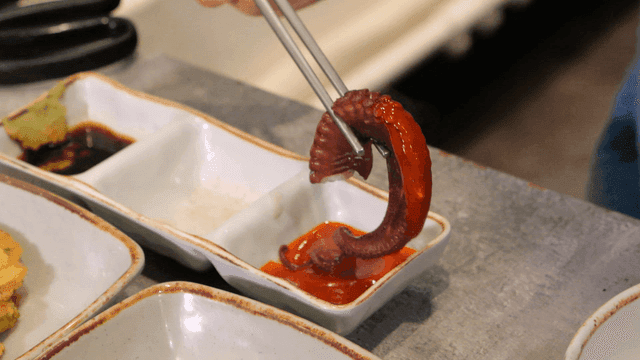 Octopus legs dipped in spicy gochujang sauce