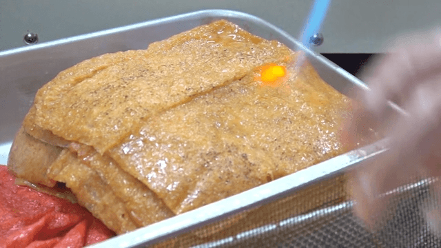 유부 표면을 토치로 굽는 장면