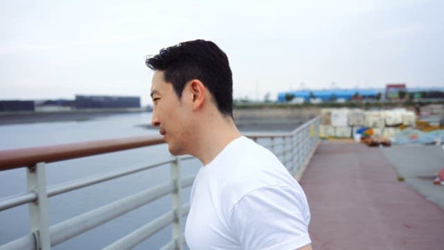 난간에 기대어 한숨을 쉬는 남자