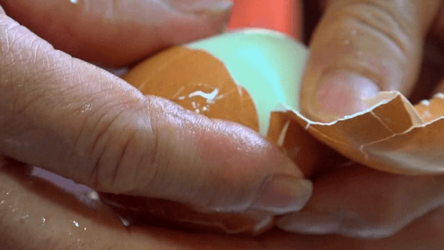 삶은 달걀을 손으로 까는 모습