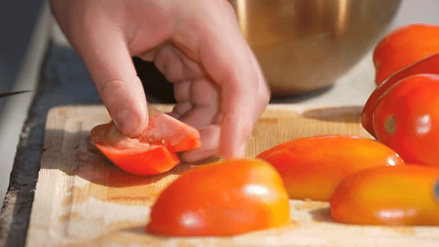 도마 위에서 신선한 토마토 자르기
