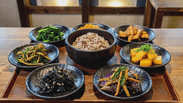 Various Korean side dishes and barley rice on table