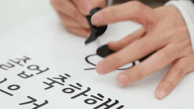 Hand removing graduation congratulatory tape with tweezers