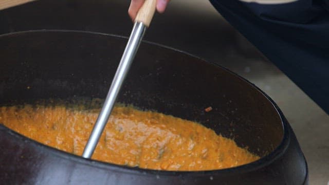 밥 위에 우유로 만든 카레를 담는 사람