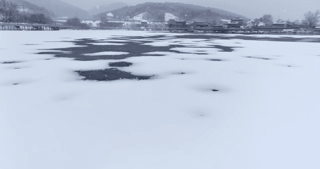 Snow falling on a frozen lake in winter