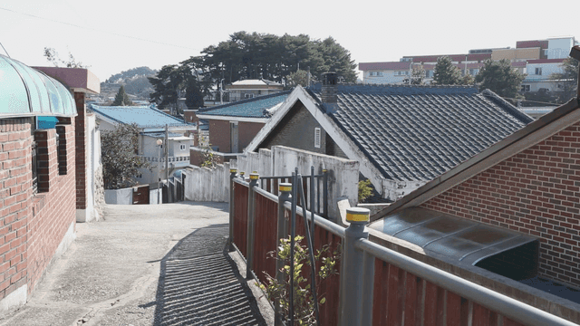 Quiet residential street with rooftops