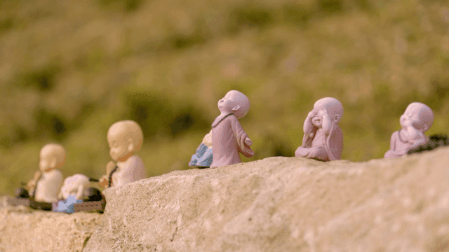 Small monk statues on a stone wall